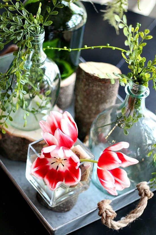 Tulips on the table  with stumps and recycled wine bottles