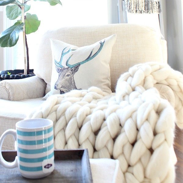 Neutral space with pops of blue and a blanket ladder for throws