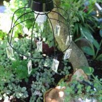 DIY-Solar-Light-Chandelier-hanging-over-rustic-tree-stump-table-and-chairs