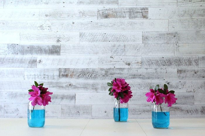 Azaleas in mason jars with blue water are perfect for the dining table