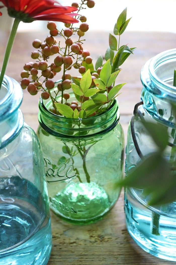 blue-and-green-mason-jars-filled-with-fall-foliage