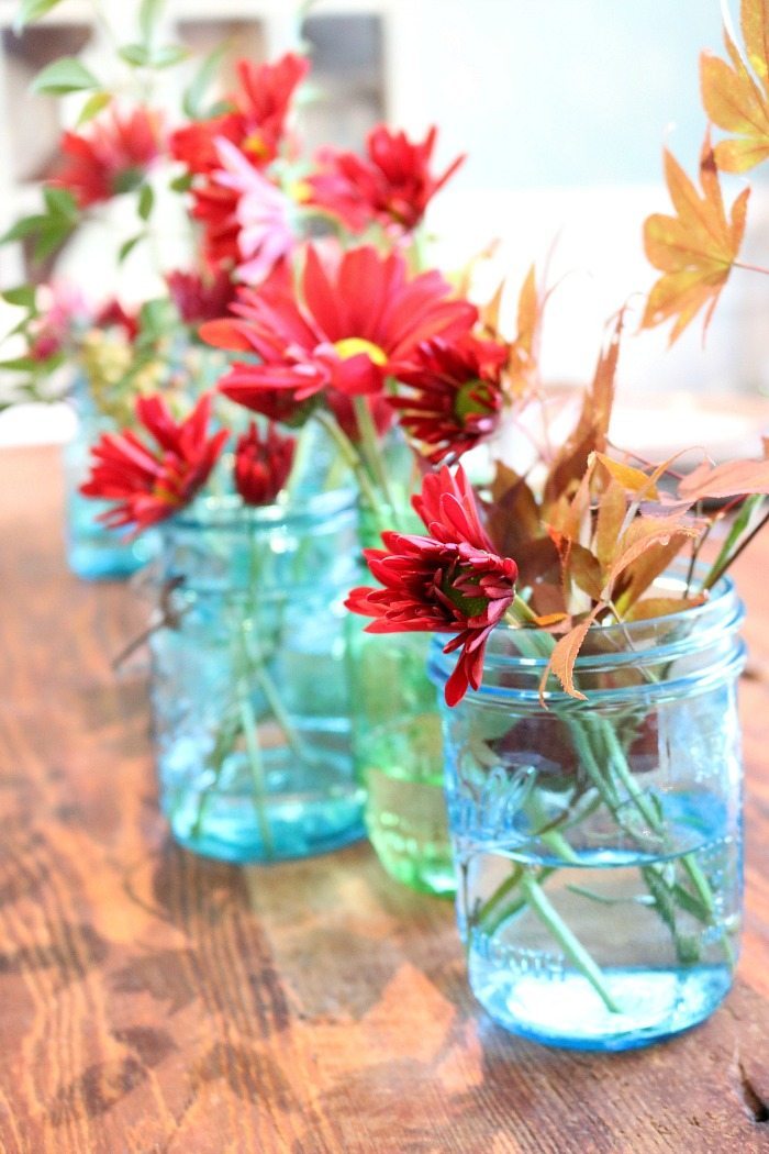 blue-mason-jars-filled-with-maple-leaves-and-mums