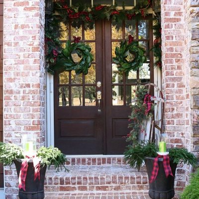 Farmhouse plaid and magnolias make a pretty Christmas Welcoming Door