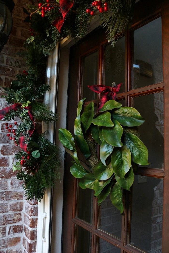 magnolia-wreath-with-plaid-ribbon-for-the-front-door-at-christmas