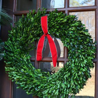 simple-red-ribbon-tied-to-a-preserved-boxwood-wreath-just-says-christmas