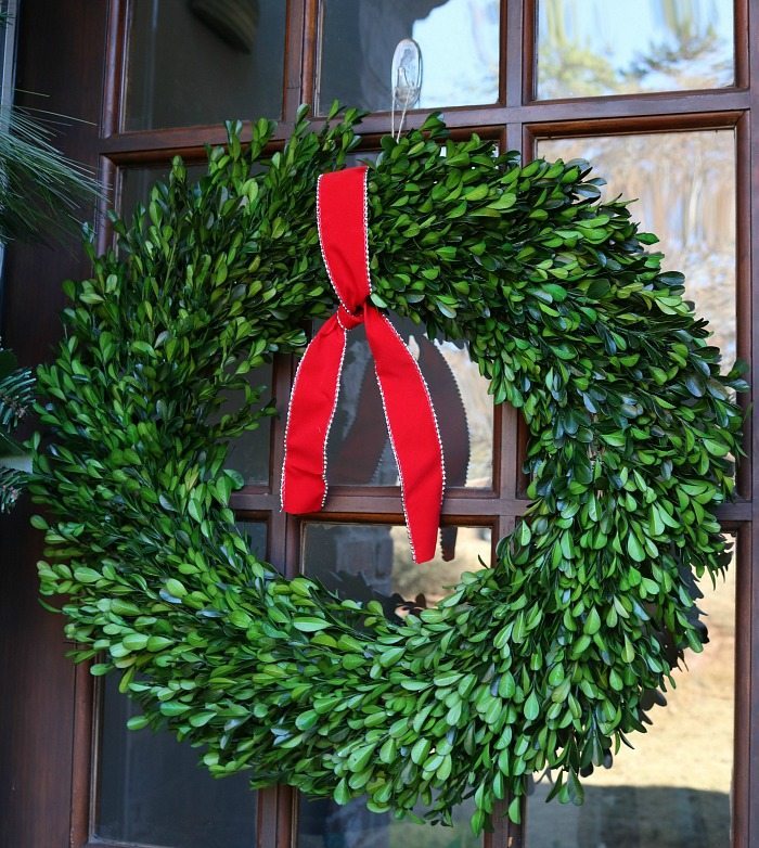 simple-red-ribbon-tied-to-a-preserved-boxwood-wreath-just-says-christmas