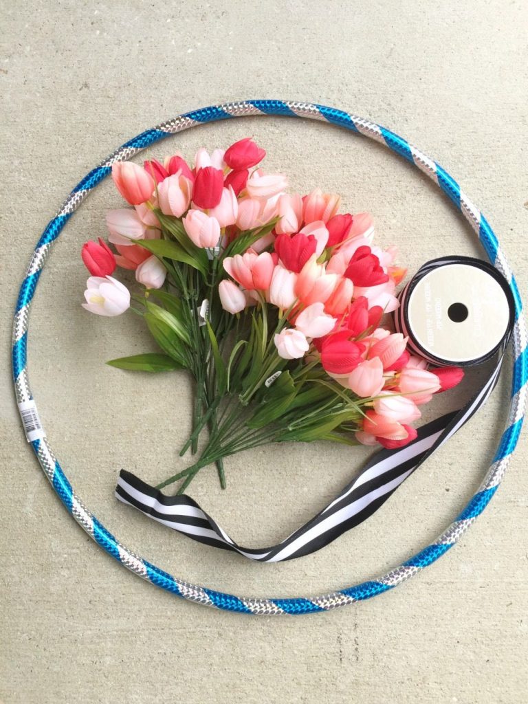 Make a hula hoop wreath with flowers and ribbon and a hula hoop