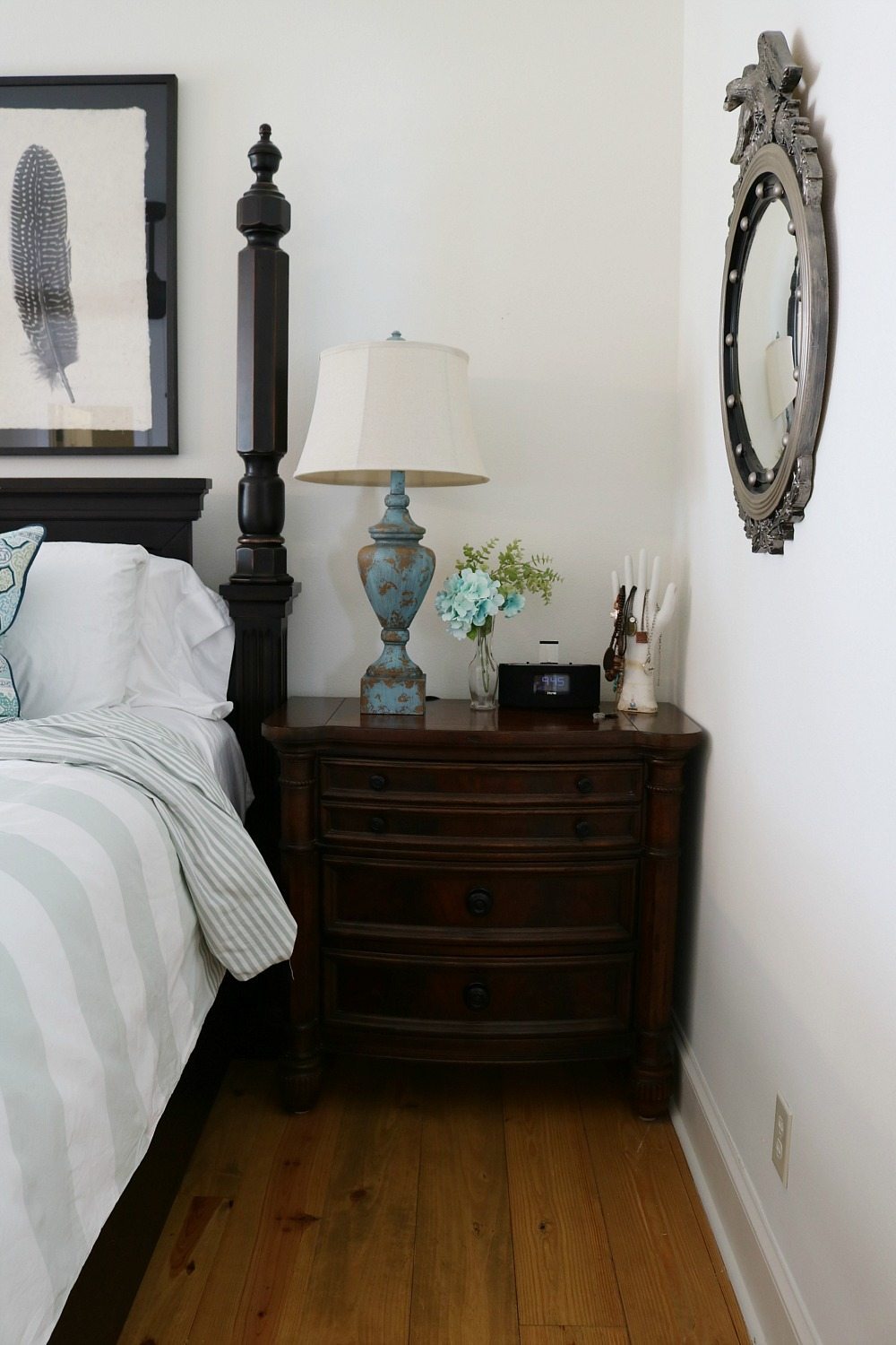 White bedroom with dark furniture and striped blue and white bedding