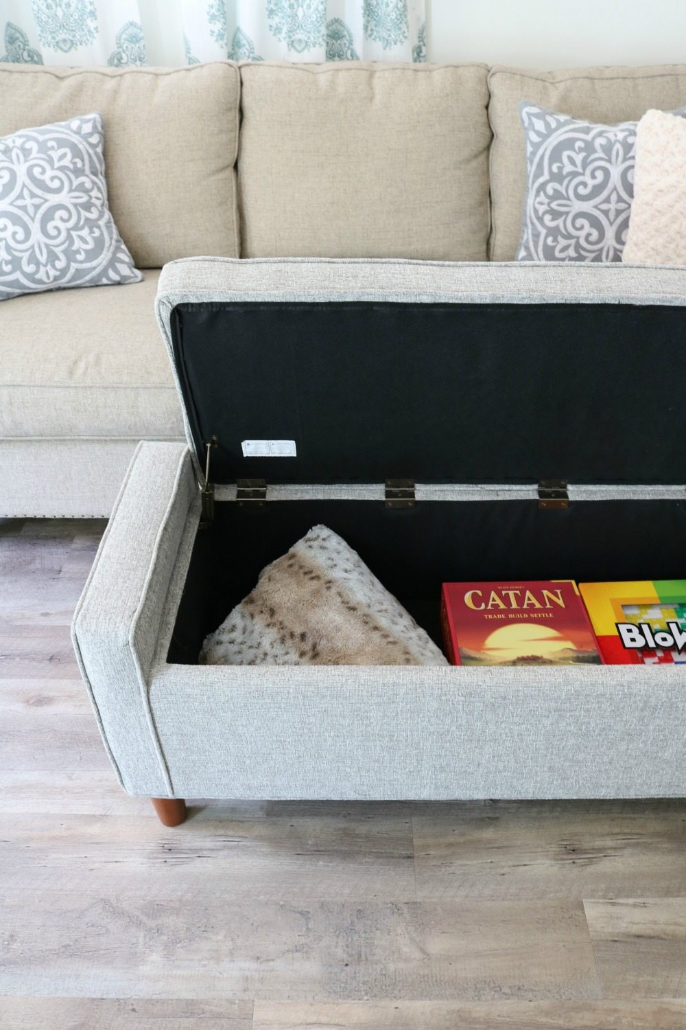 Small space living takes advantage of storage bench for living room ottoman