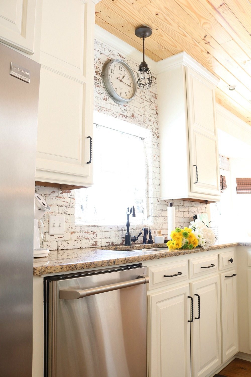 Galvanized clock on the brick wall in the kitchen at Refresh Restyle