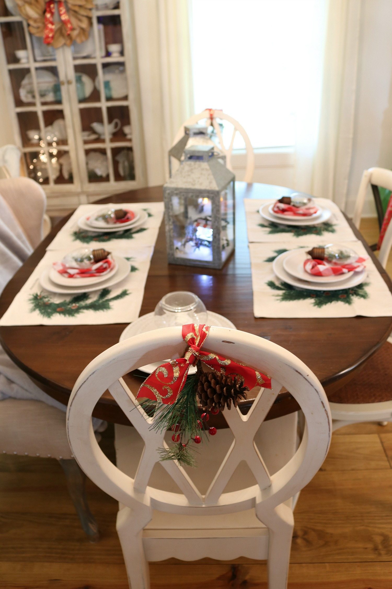 Ribbon and greenery added to the back of white chairs