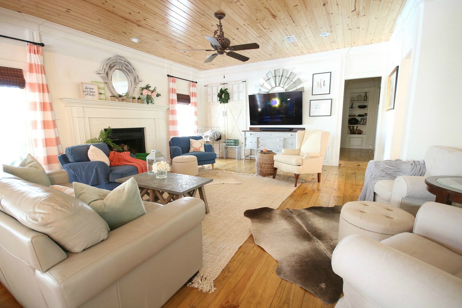 Gallery wall with tv, painted fireplace and plenty of color in this eclectic farmhouse.