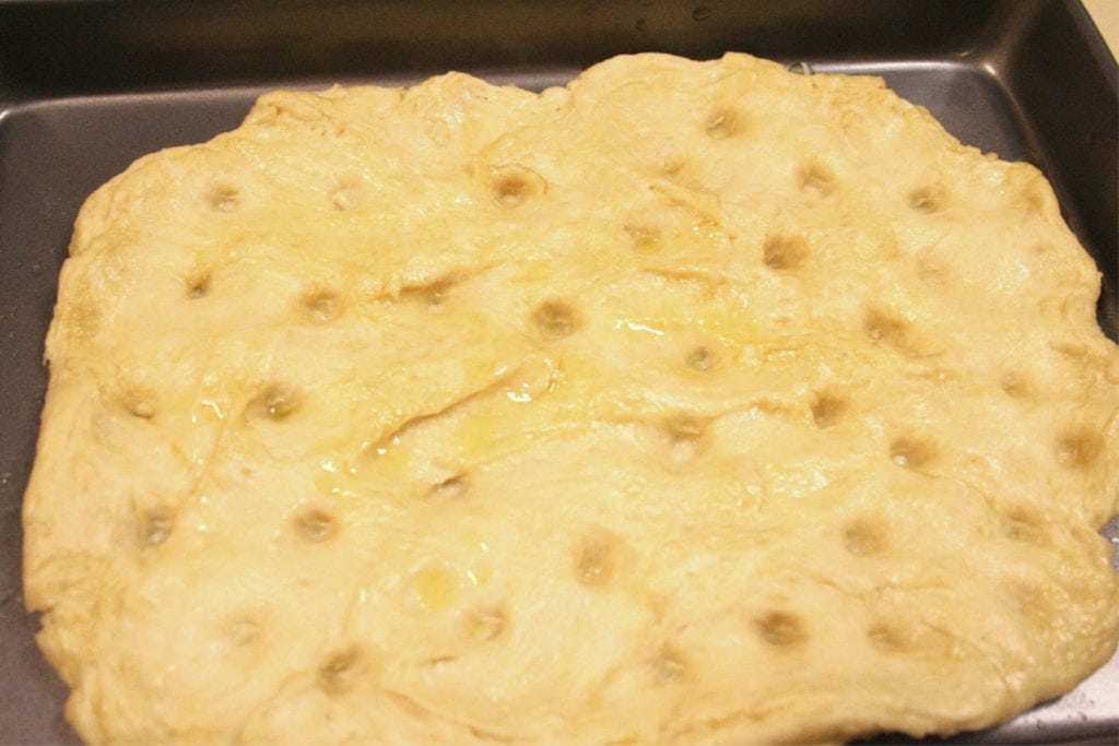 Spread and punch the focaccia bread